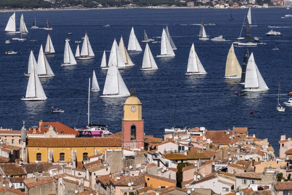La flotte des Voiles de Saint-Tropez au mouillage dans le golfe, vue au-dessus du clocher du village.